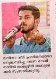 A Malayalam newspaper cutting with a photo of a man at a seminar and its short caption.